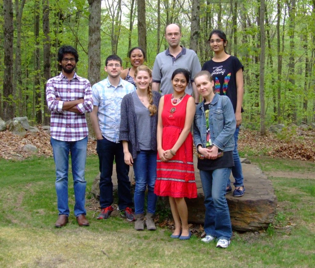 CMCD group members standing together on a lawn against a forest background.